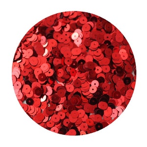 May include: A close-up image of a pile of red sequins. The sequins are round and have a shiny finish.