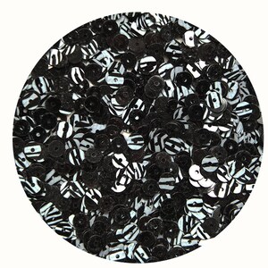 May include: Black and white zebra print sequins. The sequins are round and have a hole in the center.