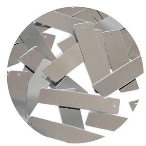 May include: A collection of small, rectangular, silver-colored metal tags with a small hole at the top. The tags are scattered and overlapping, creating a textured appearance. The tags have a shiny, reflective surface.