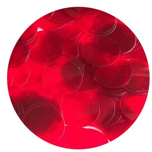 Könnte beinhalten: Nahaufnahme eines Stapels roter Pailletten. Die Pailletten sind rund und glänzend und in einem zufälligen Muster angeordnet.