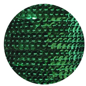May include: A close-up of a green sequin fabric. The sequins are small and round, and they are arranged in a tight, overlapping pattern.