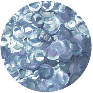 Może przedstawiać: Zbliżenie na stos iryzujących jasnoniebieskich cekinów. Ceketki są okrągłe i mają lekko wypukłe centrum.