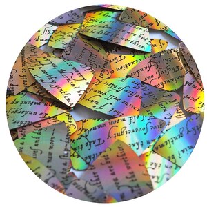 May include: A close-up of a collection of iridescent holographic sequins with a black ink print of a text passage. The sequins are shaped like teardrops and are arranged in a random pattern.