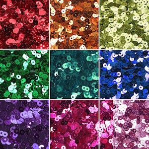 May include: Assortment of colorful round sequins in various colors, including red, orange, green, blue, purple, and pink. The sequins are arranged in a grid pattern.