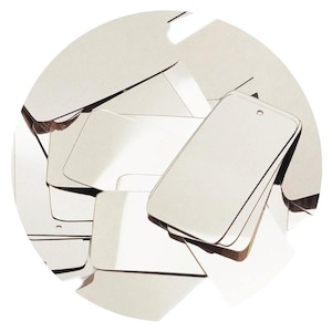 May include: A stack of silver metal gift tags with a hole punched at the top. The tags are blank and ready to be personalized.