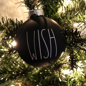 May include: Black Christmas ornament with the word "WISH" written in white on the front.