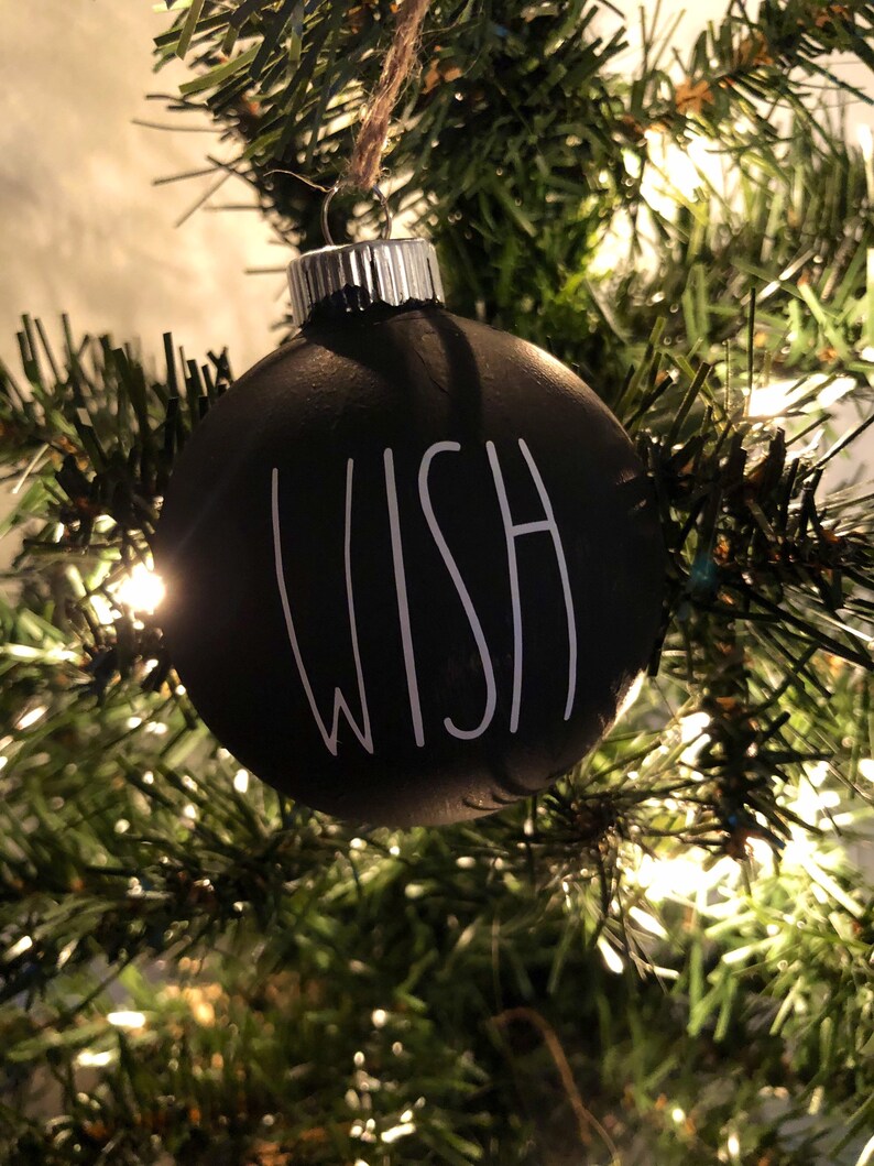 May include: Black Christmas ornament with the word "WISH" written in white on the front.