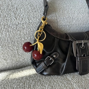 Porte-clés scintillant doré mat cerise avec breloque
