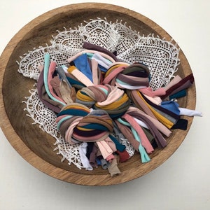 Puede incluir: Un taz&oacute;n de madera lleno de diferentes trozos de tela de colores, perfecto para proyectos de manualidades.