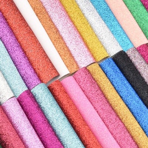 May include: A selection of glitter sheets in a range of colours, such as red, pink, gold, silver, and blue. The sheets are arranged diagonally, highlighting their sparkly texture. Suitable for crafting and decorative projects.