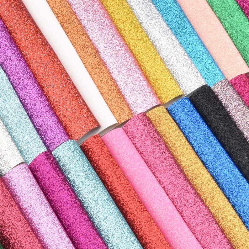 May include: A selection of glitter sheets in a range of colours, such as red, pink, gold, silver, and blue. The sheets are arranged diagonally, highlighting their sparkly texture. Suitable for crafting and decorative projects.