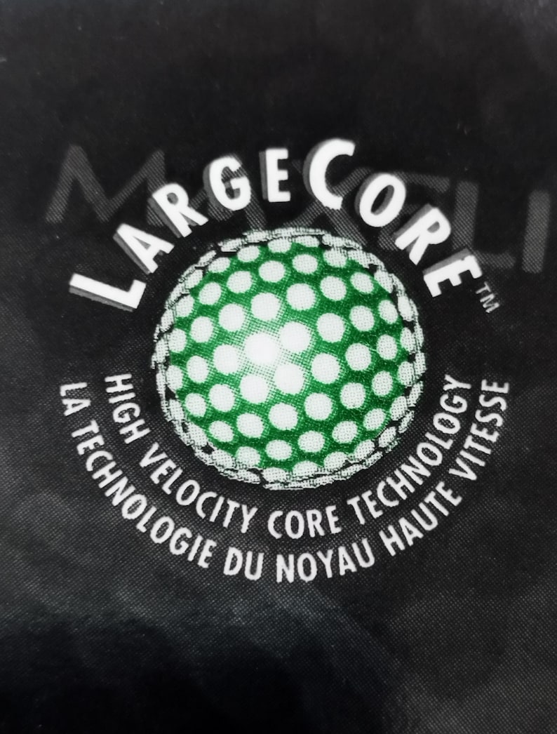 May include: A black and white logo with the text "Large Core" in a circle. The text "High Velocity Core Technology" is written in a circle around the logo. The text "La Technologie du Noyau Haute Vitesse" is written in a circle around the text "High Velocity Core Technology".