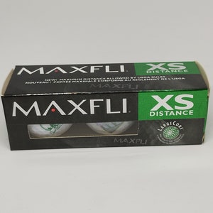 May include: A package of three Maxfli XS Distance golf balls. The package is black with green and white text. The golf balls are white with green and white markings.