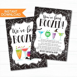 May include: Two Halloween-themed printable signs with the text "We've been BOOZED!" and "You've been BOOZED!" in a black and white spiderweb design. The signs feature colorful cocktail illustrations and Halloween-related text.