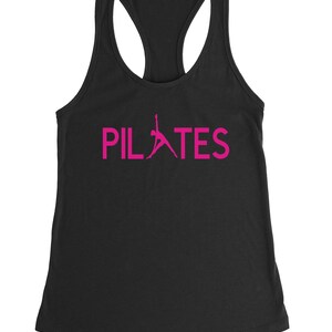May include: Black tank top with a pink silhouette of a person doing pilates and the word "PILATES" in pink.