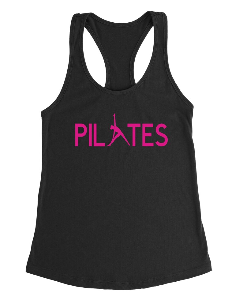 May include: Black tank top with a pink silhouette of a person doing pilates and the word "PILATES" in pink.