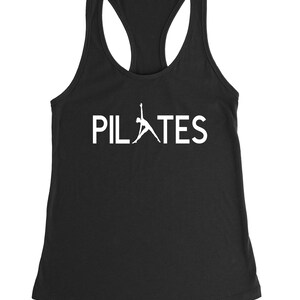 May include: Black tank top with a white silhouette of a person doing a pilates pose and the word "PILATES" in white text.