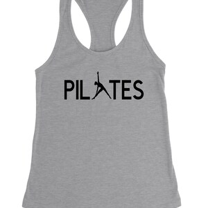 May include: A grey tank top with a black silhouette of a person doing a pilates pose and the word "PILATES" in black text.