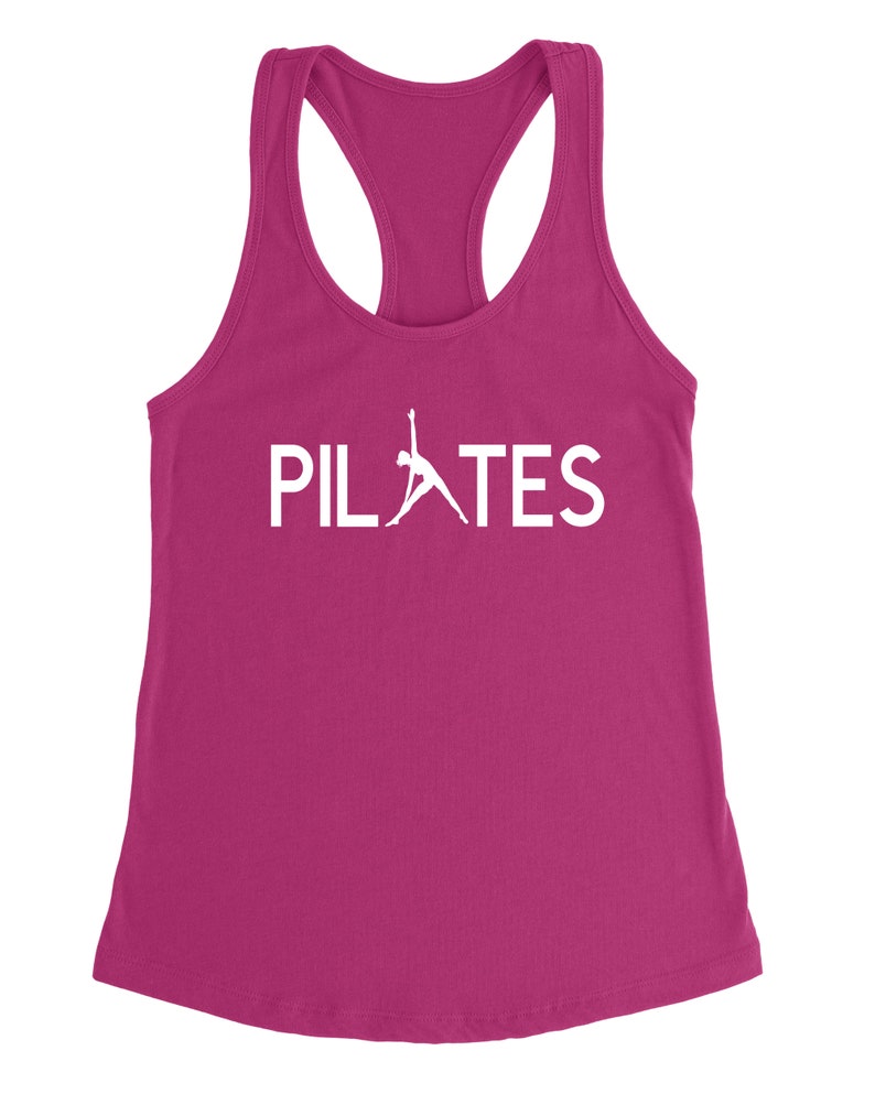 May include: A pink tank top with a white silhouette of a person doing a pilates pose and the word "PILATES" in white text.