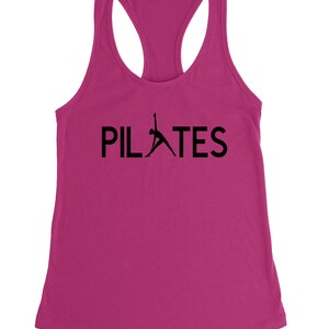May include: A pink tank top with a black silhouette of a person doing pilates and the word "PILATES" in black text.