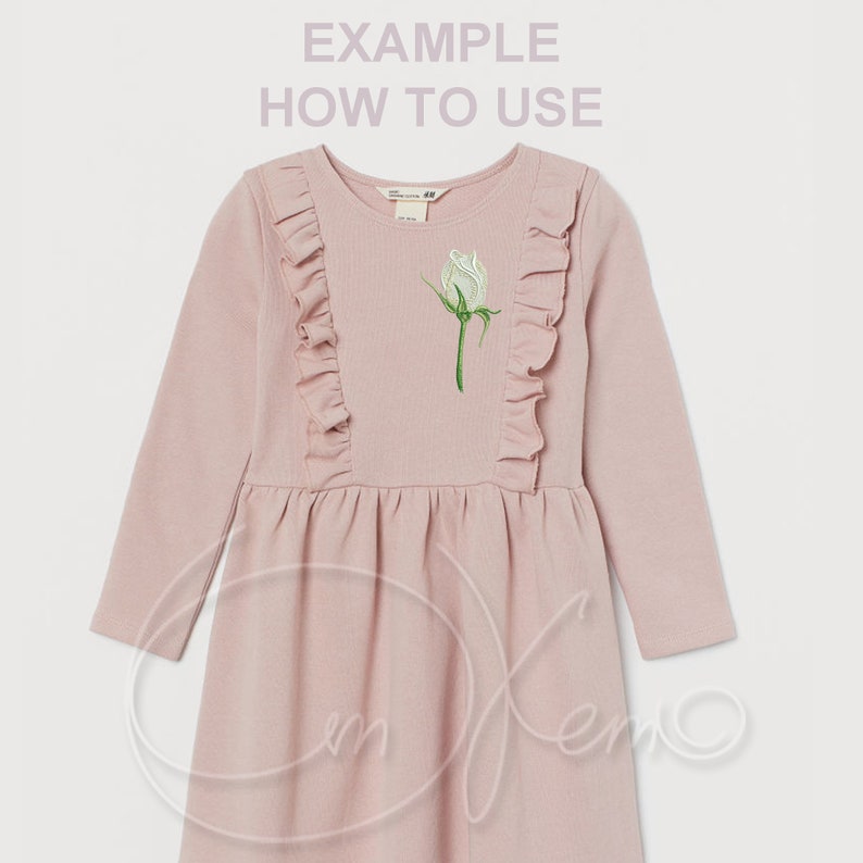May include: A pink long-sleeved dress with a white rose embroidered on the front. The dress has ruffles on the shoulders and a flared skirt.