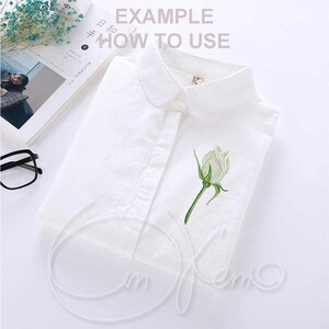 May include: White button-down shirt with a white rose embroidered on the front. The shirt has a collar and a single button closure. The text "EXAMPLE HOW TO USE" is printed on the shirt.
