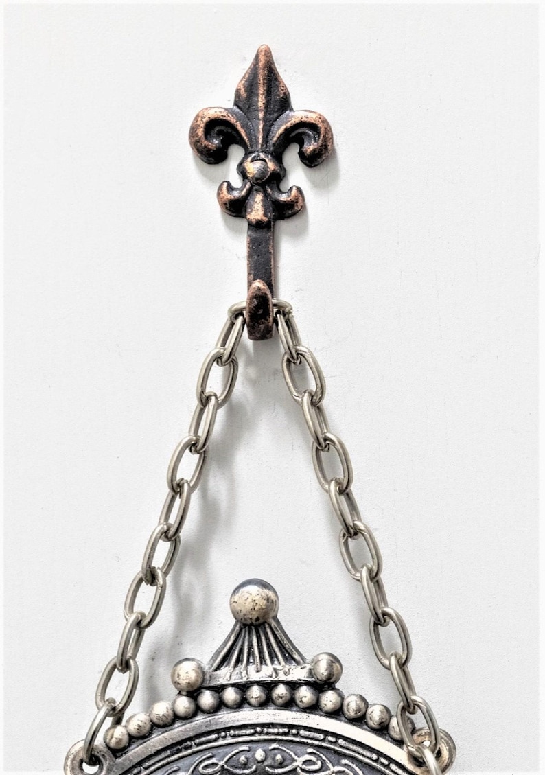 Mini bronze fleur de lis hooks hanging a photo frame