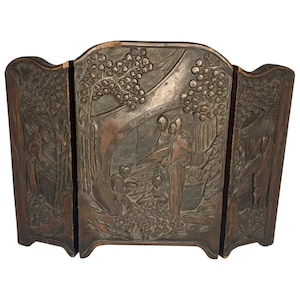 May include: A three-panel wooden screen with intricate carvings depicting a scene of people in a garden setting. The screen is made of dark wood and has a rustic, antique look.
