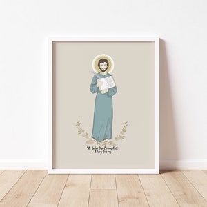 May include: A printable art print featuring a digital illustration of Saint John the Evangelist. The illustration depicts Saint John holding a book and a quill pen. The background is a light beige color with a floral design at the bottom. The text "St. John the Evangelist Pray for us" is printed below the illustration.