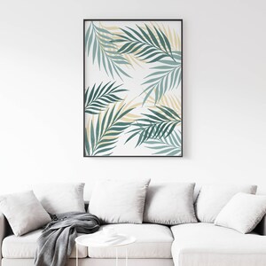 May include: A framed print with a white background and a pattern of green and yellow palm leaves.