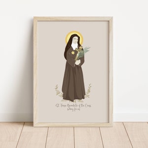 Puede incluir: Una impresión de arte imprimible con una ilustración digital de Santa Teresa Benedicta de la Cruz, también conocida como Edith Stein. La ilustración la representa con un hábito marrón y un velo blanco, sosteniendo una cruz y una rama de palma. El texto "St. Teresa Benedicta of the Cross Pray for us" está impreso debajo de la ilustración.