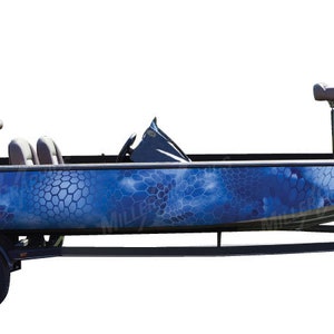 Pu&ograve; includere: Una barca da pesca mimetica blu e nera con un rimorchio. La barca ha due sedili e un motore.
