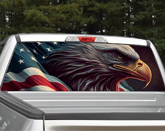 May include: A truck's rear window with a decal of an American flag and a bald eagle. The eagle's head is facing right and the flag is waving behind it.