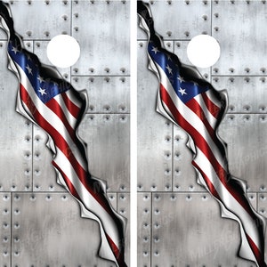May include: Two metal cornhole boards with a distressed metal look. The boards have a large hole in the center and a tattered American flag peeking through the hole.