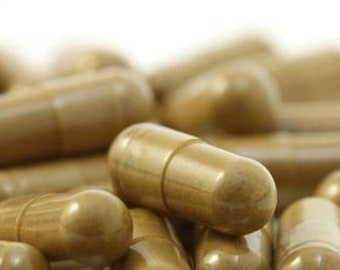May include: A close-up of a pile of brown capsules. The capsules are arranged in a random pattern and are all the same size and shape.