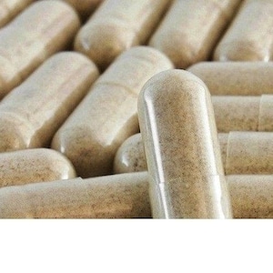 May include: A close-up of a pile of beige capsules. The capsules are arranged in a random pattern, with some capsules overlapping others. The capsules are all the same size and shape.