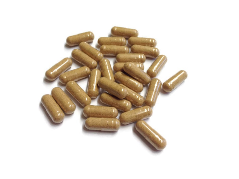 May include: A pile of brown capsules on a white background.