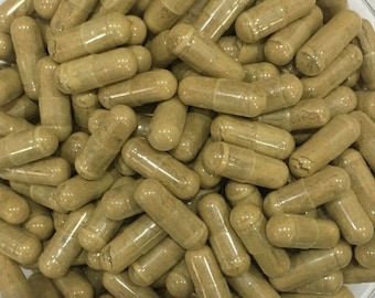 May include: A close-up image of a large quantity of brown capsules. The capsules are filled with a light brown powder. The capsules are arranged in a random pattern.
