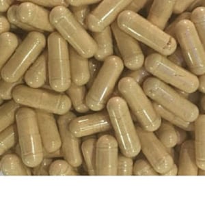 May include: A large quantity of beige capsules in a clear container.