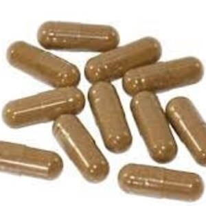 May include: A group of ten brown capsules, likely a dietary supplement or herbal remedy.
