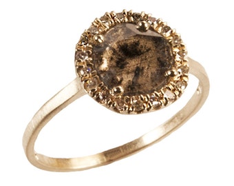May include: A gold ring with a large, round, brown gemstone surrounded by a halo of smaller diamonds.