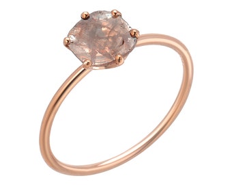 May include: A rose gold ring with a clear, faceted gemstone set in a prong setting.
