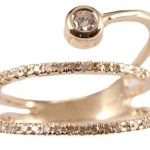 May include: A gold ring with a single diamond set in a bezel setting. The ring has a double band with a row of small diamonds on each band.
