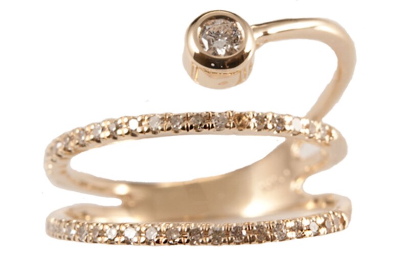 May include: A gold ring with a single diamond set in a bezel setting. The ring has a double band with a row of small diamonds on each band.