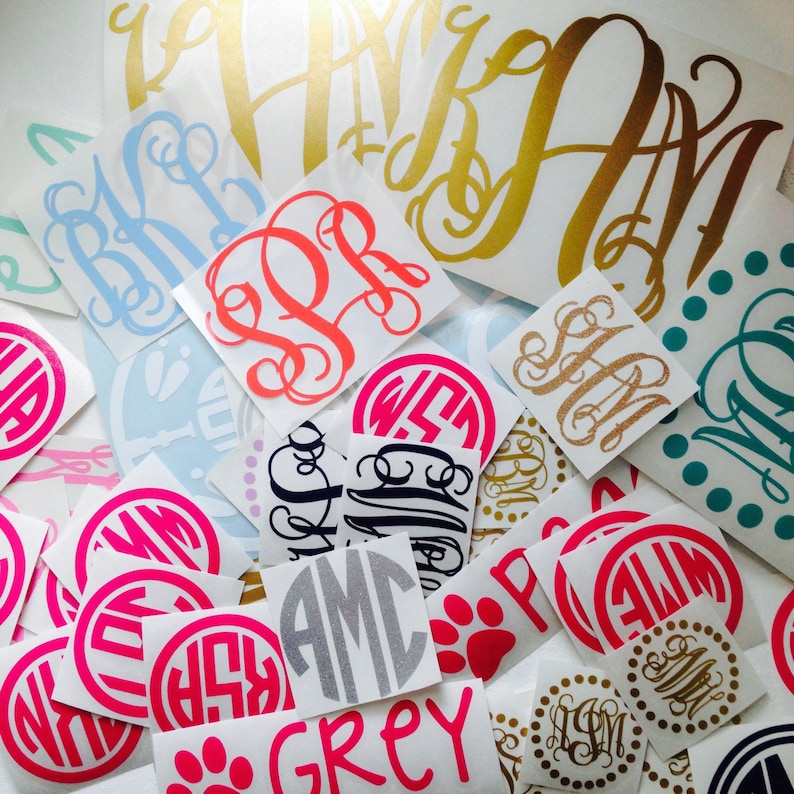 May include: Assortment of colorful monogram decals in various styles and colors, including pink, blue, red, gold, and black. The decals are perfect for adding a personalized touch to any surface.
