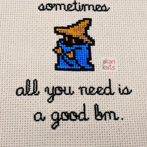 May include: Cross-stitch embroidery on a beige fabric with a pixelated image of a blue and brown wizard character. The text "sometimes all you need is a good bm." is stitched in black thread.