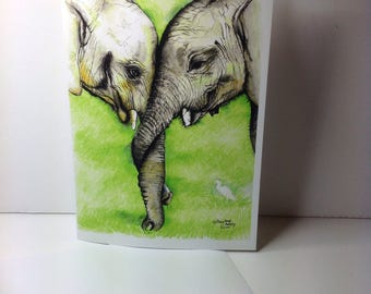 May include: A watercolor painting of two elephants with their trunks intertwined. The elephants are in a green field with a white bird in the background. The painting is signed by the artist.