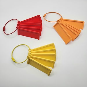 May include: Five red, five orange, and five yellow plastic keychains with a metal ring. Each keychain has a rectangular tag with a rounded edge.
