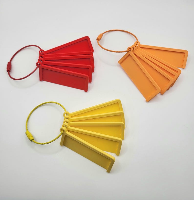 May include: Five red, five orange, and five yellow plastic keychains with a metal ring. Each keychain has a rectangular tag with a rounded edge.