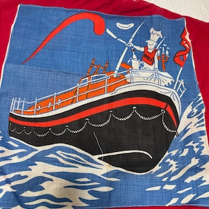 May include: A red jacket with a blue and white patch featuring a lifeboat with a person holding a lifebuoy and a flag that says "RNLI".